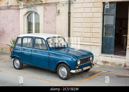 Bella auto d'epoca di fronte a tipiche case cittadine in una città mediterranea in Sicilia, Italia Foto Stock