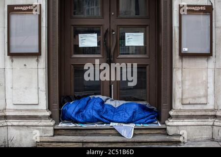 I senzatetto dormiscono sui gradini del ristorante chiuso Assaggetti su Haymarket, West End, Londra, UK Foto Stock