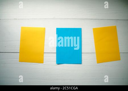 Nota colorata con caratteri adesivi su sfondo in legno con alfabeto in legno. Foto Stock