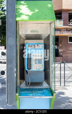 Jaen, Spagna - 18 giugno 2020: Chiosco telefonico pubblico lungo una strada del centro città. Uno dei vecchi e inutili telefoni pubblici che rimane in pubblico modi in S Foto Stock