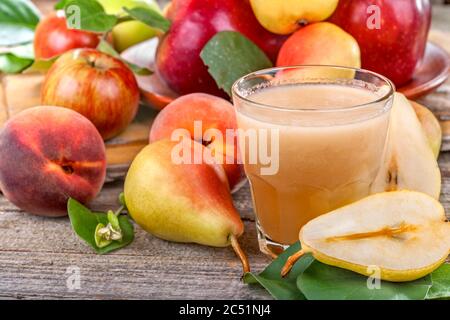 Spremuta fresca fatta da pere, mele e pesche biologiche e sane. Primo piano. Foto Stock