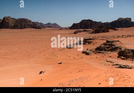 Vista dalla cima della duna di sabbia di veicoli 4x4 nella valle del deserto di Wadi Rum, Giordania, Medio Oriente Foto Stock