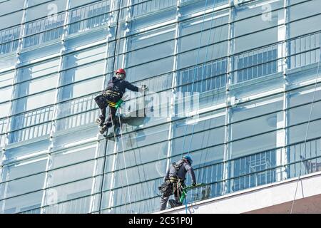Pulitore per finestre su facciata di vetro di un grattacielo Foto Stock