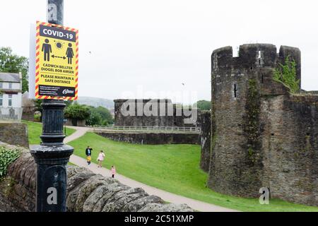 Caerphilly, Galles, Regno Unito. 30 giugno 2020. Avviso di informazione di distanza sociale del Coronavirus Covid-19 su un lampione nel centro di Caerphilly. Credit: Tracey Paddison/Alamy Live News Foto Stock