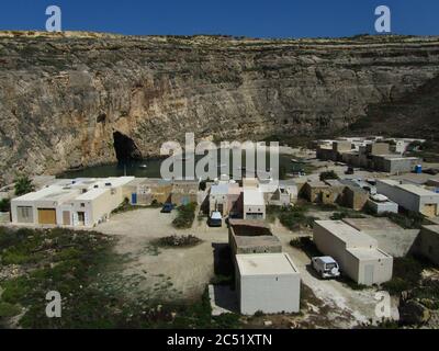 DWEJRA GOZO, MALTA - 27 settembre 2012: Una laguna di mare interna, nella baia di Dwejra, Gozo, circondata da piccole boathouses e con alcune piccole imbarcazioni galleggianti. A na Foto Stock