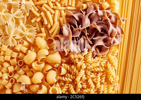 Cumulo di pasta cruda o maccheroni di vario tipo e forma. Vista dall'alto. Foto Stock