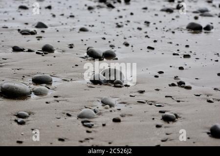 Sfondi naturali e texture di ciottoli, pietre e rocce sulla spiaggia nel Galles del Sud. Primo piano dei diversi modelli di dimensioni. Foto Stock