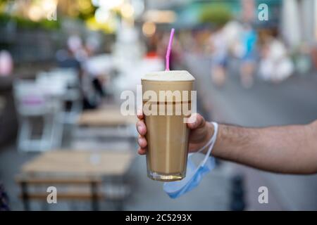 primo piano mano uomo tenendo frappé, fuoco selettivo Foto Stock