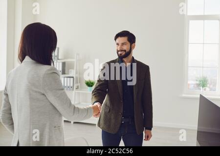 Sorridente uomo formale e donna che si incontrano in ufficio Foto Stock