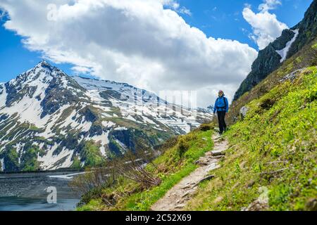 Donna escursioni lungo un sentiero nelle Alpi austriache vicino a Gastein, Salisburgo, Austria Foto Stock