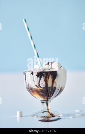 Frullato con condimento al cioccolato in una tazza da cocktail in vetro, decorata con marshmallows Foto Stock