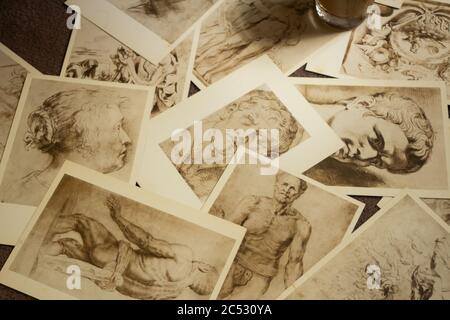 Le vecchie cartoline sono sparse in modo caotico e una tazza si trova su di loro Foto Stock