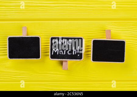 Tre piccole targhette su un tavolo di legno giallo. Foto Stock