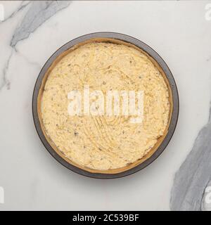 Vista in pianta della pastella per torte in una latta foderata, pronta per essere cotta. Foto Stock