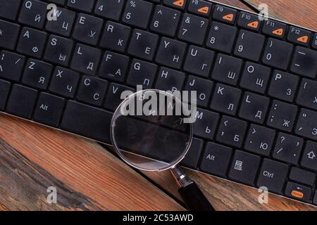 Lente di ingrandimento su tastiera nera. Foto Stock