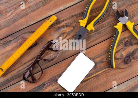 Attrezzi manuali per la costruzione sul piano di lavoro - pinze, tronchesi, righello. Foto Stock