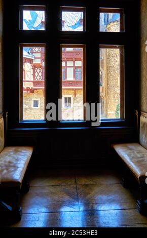 Vecchia grande finestra in legno con due panche in pelle. Castello di Wernigerode in Germania. Foto Stock