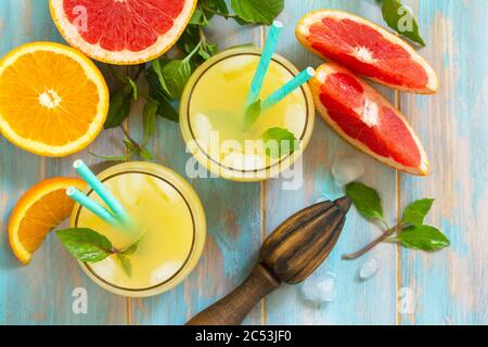 Drink estivo. Bevanda rinfrescante all'arancia e al pompelmo con ghiaccio. Vista dall'alto sfondo piatto. Foto Stock