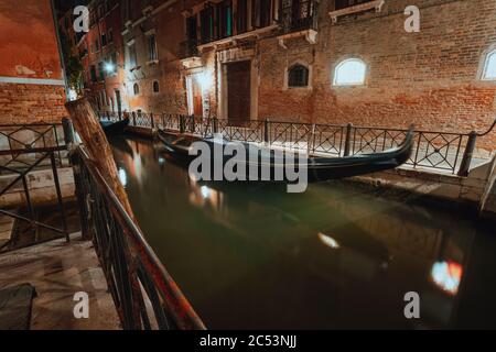Venezia Gondola barca in piccolo canale nella città lagunare Venezia di notte. Lunga esposizione Venezia Italia. Foto Stock
