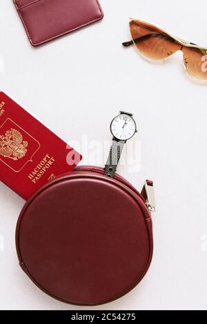 Corsa minima femmina impostata. Passaporto, titolare e portafoglio con una borsa e bicchieri su sfondo beige pastello. Foto Stock