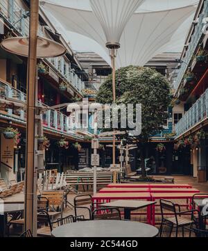 Londra, UK - 13 giugno 2020: Tavoli vuoti all'interno di Kingly Court, un cortile con cibo e ristoranti all'aperto a tre piani nel cuore del West End di Londra. Selec Foto Stock