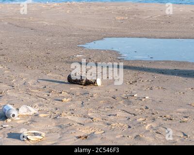 Detriti sparsi sulla spiaggia.disastro ambientale.impronte umane. Foto Stock