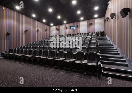 Mosca - 24 luglio 2014: Vista panoramica di una sala cinema vuota. All'interno del teatro scuro e confortevole. Design contemporaneo di auditorium cinematografico. Panorama o Foto Stock