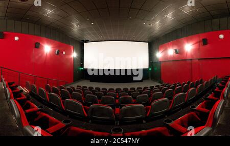 Mosca - 9 febbraio 2012: Vista panoramica di una sala cinema vuota con schermo. Auditorium cinematografico dal design contemporaneo con sedili rossi. Non completamente sferica p Foto Stock