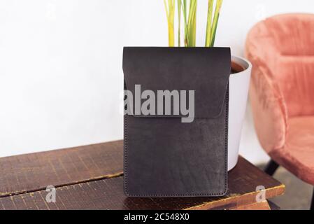 copertura per laptop in un bellissimo loft interno. Custodia in pelle per tablet realizzata a mano. Pelle ecologica. Foto Stock