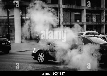 Scena invernale bianca e nera con vapore e macchine in movimento su una strada a Washington, D.C. Foto Stock