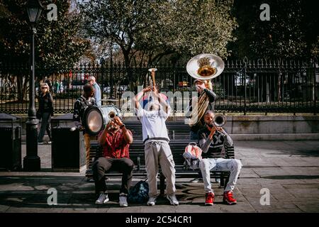 Cinque musicisti jazz del sud suonano una canzone su una panchina del parco fuori da Jackson Square nel quartiere francese di New Orlean Foto Stock