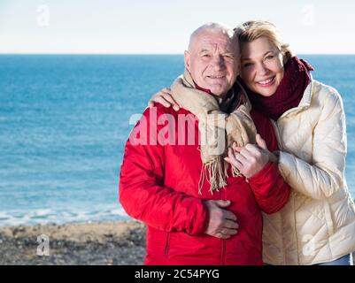 Di età compresa tra il marito e la moglie facendo una passeggiata sulla spiaggia nella stagione fredda Foto Stock