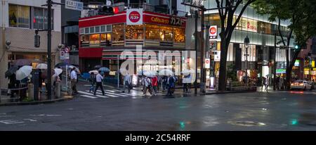 Persone con ombrello a piedi al Dogenzakue Street Sidewalk, Tokyo, Giappone Foto Stock