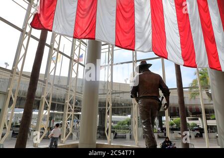 Una statua di John Wayne, di grandi dimensioni e con bandiera americana, con l'aeroporto John Wayne. Santa Ana.Orange County.California.USA Foto Stock