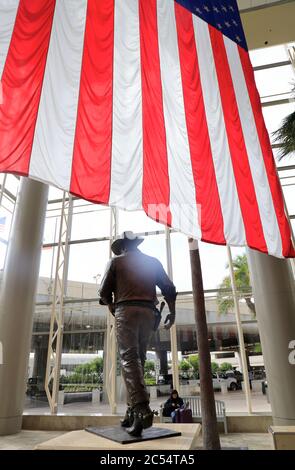 Una statua di John Wayne, di grandi dimensioni e con bandiera americana, con l'aeroporto John Wayne. Santa Ana.Orange County.California.USA Foto Stock