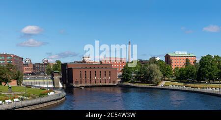 Tammerkoski -canale è il punto di riferimento più iconico della città di Tampere. La vecchia centrale elettrica e gli edifici della fabbrica dominano la vista durante il caldo giorno estivo. Foto Stock