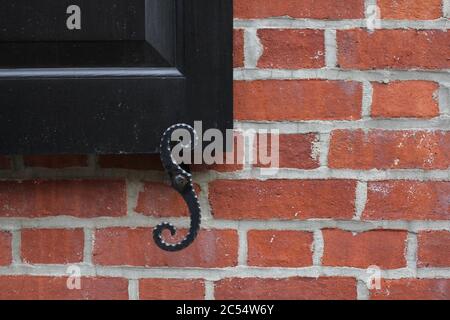 Closeup di una vecchia struttura di mattoni rossi con un tradizionale cane in acciaio nero Foto Stock