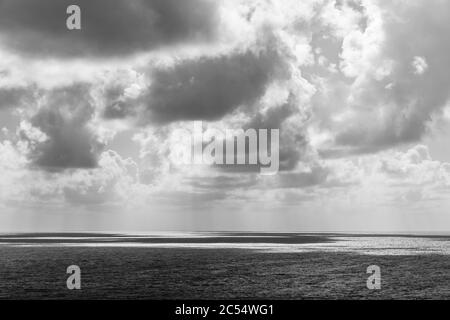 Nero e bianco di nuvole che gettano le loro ombre sulla superficie del mare Foto Stock