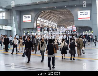 Lavoratori pendolari Salaryman che camminano alla stazione ferroviaria di Shinawaga, Tokyo, durante le ore di punta del mattino. Foto Stock