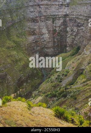 Santo Antao, Capo Verde. Crinale di montagna con cascata secca di canyon con ripida scogliera e tortuoso letto del fiume con vegetazione lussureggiante. Foto Stock