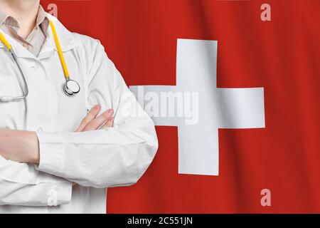 Concetto sanitario della Confederazione svizzera con medico sullo sfondo della bandiera svizzera. Assicurazione medica, lavoro o studio nel paese Foto Stock