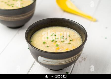 Zuppa di pollo e mais asiatica. Un piatto di cucina Cantonese spesso servito come antipasto nei ristoranti cinesi. La ciotola della zuppa è su sfondo bianco. Ad es Foto Stock