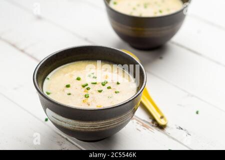 Piatto di zuppa di mais cinese. Un piatto di cucina Cantonese spesso servito come antipasto nei ristoranti cinesi. La ciotola della zuppa è su sfondo bianco. Foto Stock