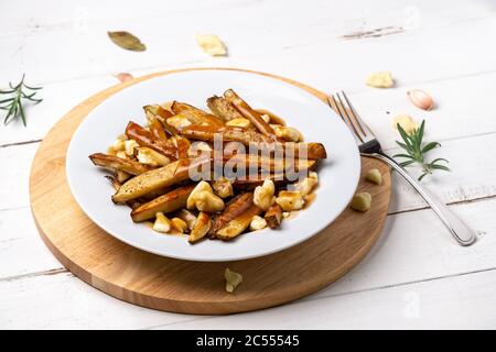 Patatine fritte su bianco. Un classico piatto di cucina fast food dal Quebec. Questo cibo canadese è fatto con patatine fritte mescolate con tast Foto Stock