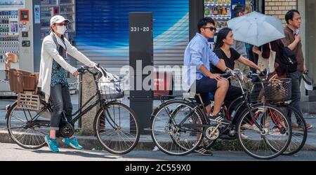 Persone in bicicletta a Shibuya Street, Tokyo, Giappone Foto Stock