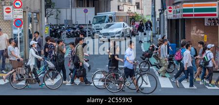 Persone in bicicletta a Shibuya Street, Tokyo, Giappone Foto Stock