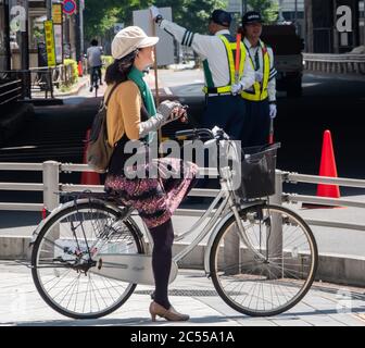 Persone in bicicletta a Shibuya Street, Tokyo, Giappone Foto Stock