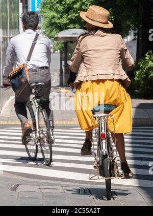 Persone in bicicletta a Shibuya Street, Tokyo, Giappone Foto Stock