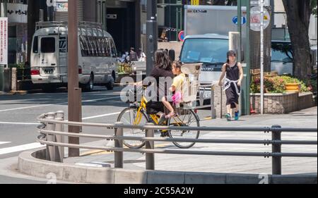 Persone in bicicletta a Shibuya Street, Tokyo, Giappone Foto Stock