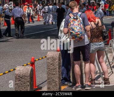 Turisti stranieri persi chiedendo assistente dal personale di sicurezza in via Shibuya, Tokyo, Giappone Foto Stock